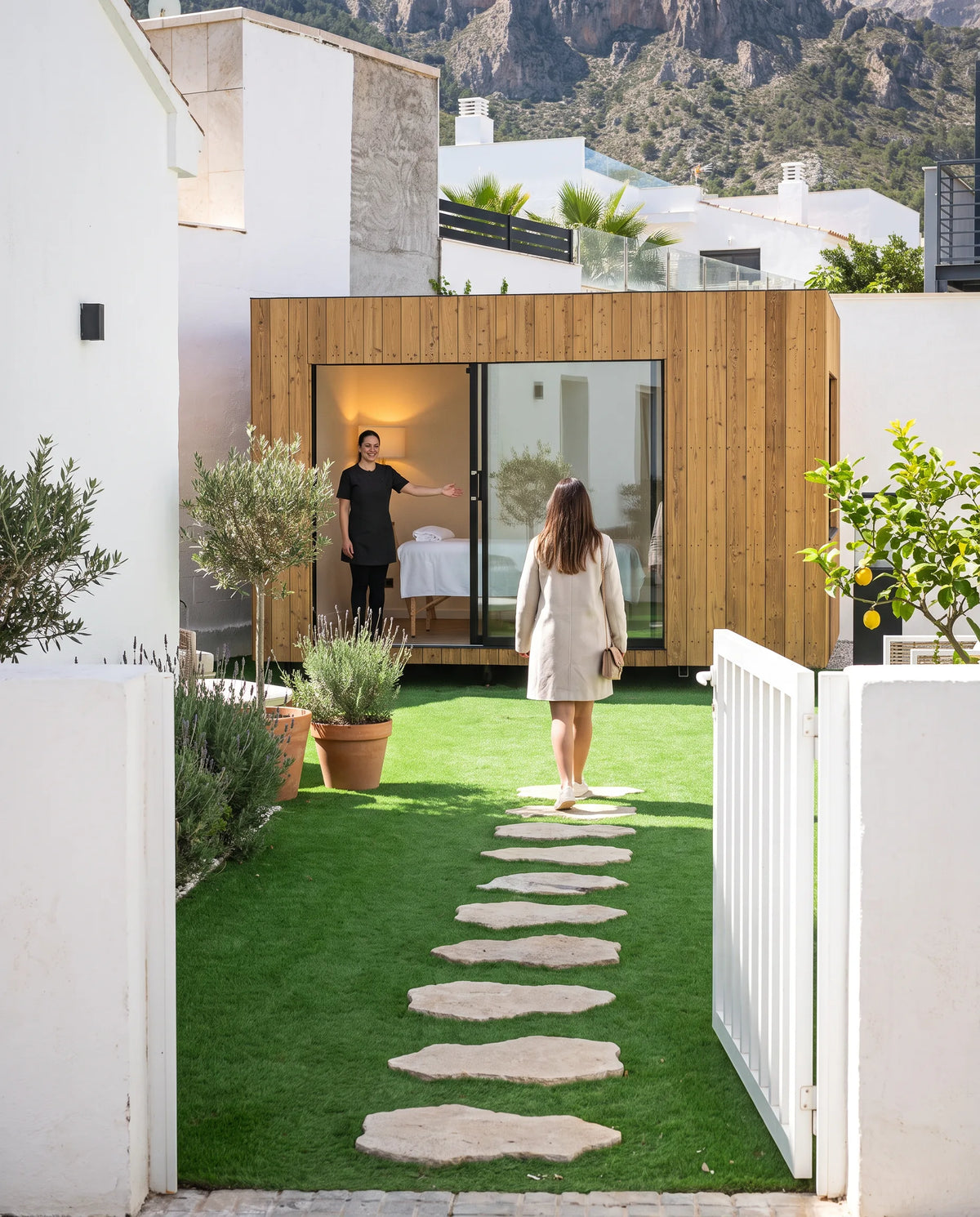 Visualización de una clienta llegando por el jardín a un NOOK 10 con la puerta abierta, sin pasar por la casa