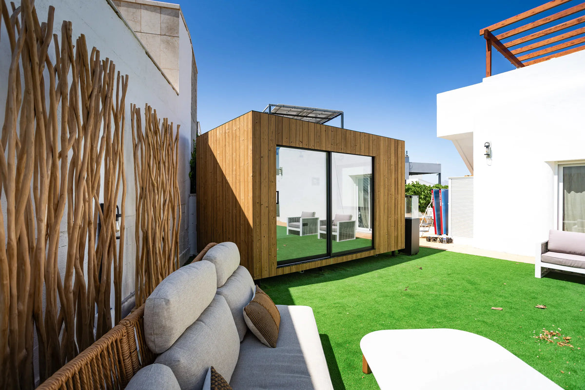 Un NOOK 10 de roble visto desde el sofá del jardín, con las puertas de vidrio cerradas