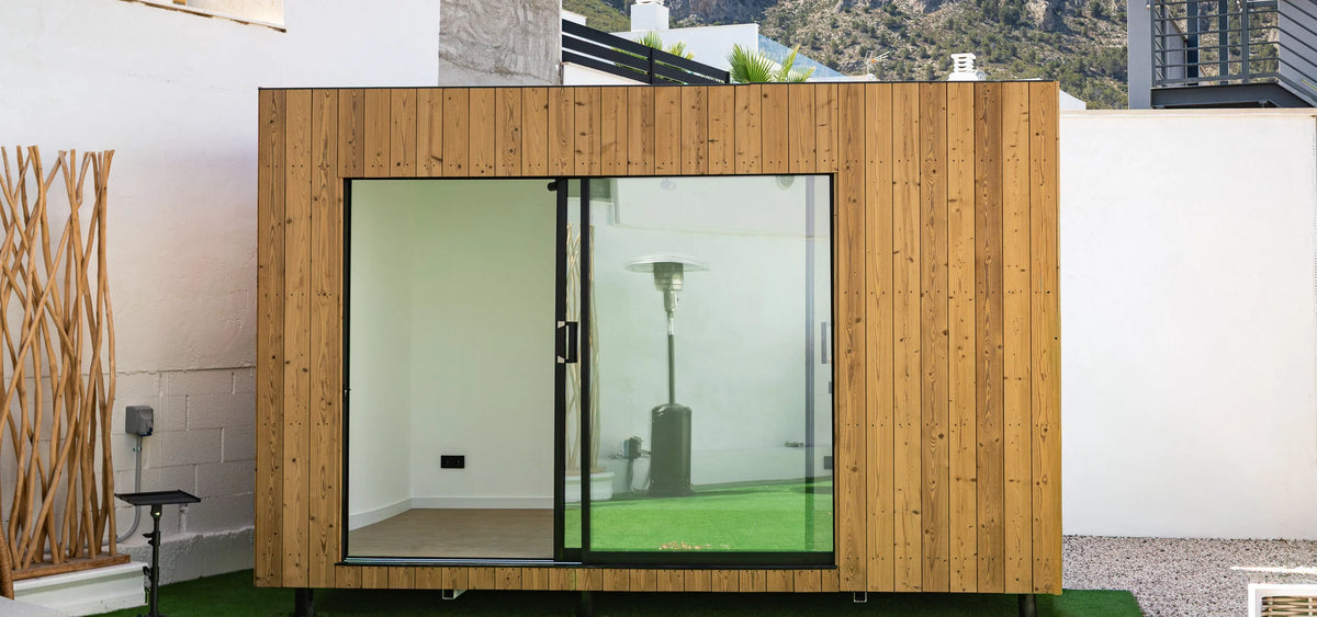 Un NOOK 10 de roble visto de frente en su jardín, con las montañas detrás